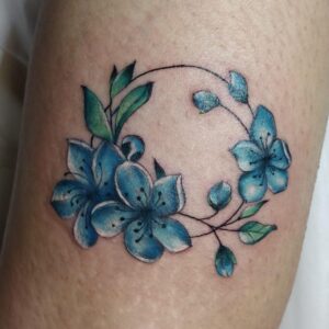 קעקוע של פרחים כחולים בביצוע של טוני בלוסטון