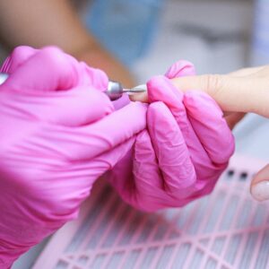 יד עושה מניקור עם כפפות ורודות