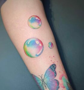 קעקוע של בועות סבון צבעוניות ביצוע של בוגרת קורס קעקועים מקיף של TATTOOTLV