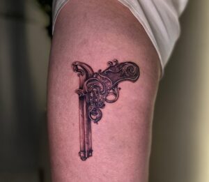 קעקוע אקדח על הרגל ביצוע של בוגרת קורס קעקועים מקיף של TATTOOTLV