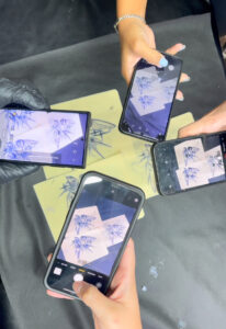 4 סמארטפונים מצלמים עור מזויף לאחר שסיימו לקעקע אותו בקורס קעקועים