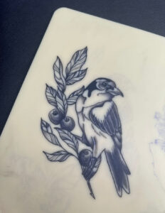 ציפור עם עלים שקועקעה על עור מזויף במסגרת קורס קעקועים אקדמיית מאמא אינק