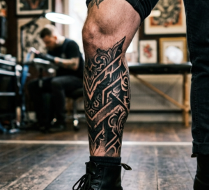 קעקוע גדול על הרגל בסגנון בלאקוורק